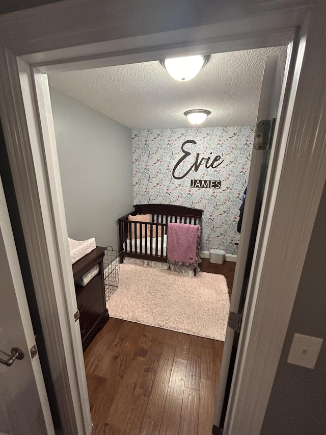 bedroom with dark hardwood / wood-style floors and a textured ceiling