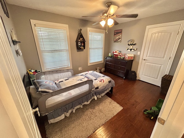 bedroom with ceiling fan and dark hardwood / wood-style flooring