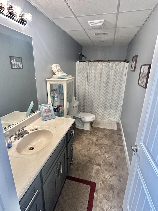 bathroom featuring vanity, toilet, curtained shower, and a drop ceiling