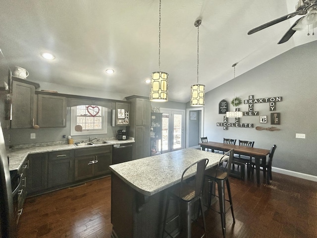 kitchen featuring dark wood-type flooring, dishwasher, hanging light fixtures, a kitchen island, and vaulted ceiling