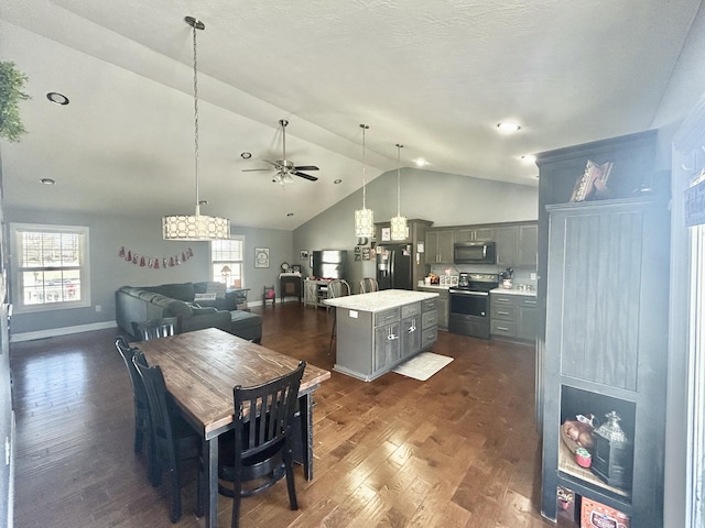 kitchen featuring pendant lighting, dark wood-type flooring, gray cabinetry, stainless steel appliances, and a kitchen island