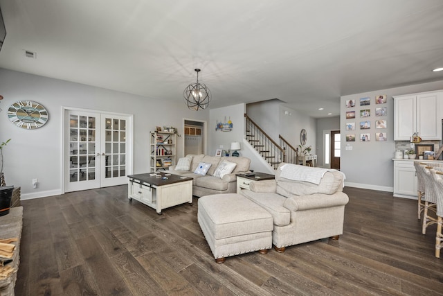 living room featuring an inviting chandelier, dark hardwood / wood-style floors, and french doors