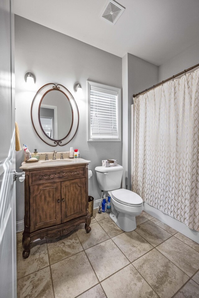 bathroom featuring vanity, tile patterned floors, and toilet