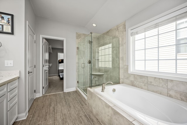 bathroom with vanity, shower with separate bathtub, and a healthy amount of sunlight