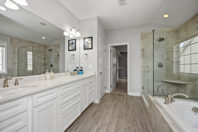 bathroom featuring vanity, vaulted ceiling, and shower with separate bathtub