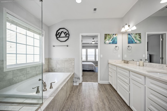 bathroom featuring vanity and tiled bath