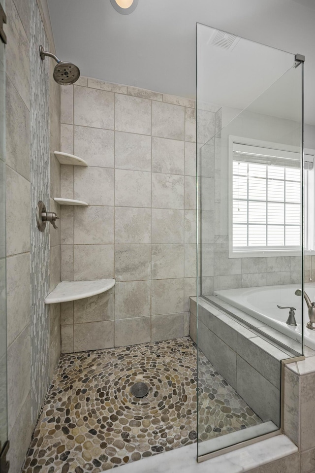 bathroom featuring shower with separate bathtub