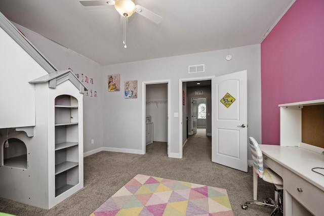 carpeted bedroom with a spacious closet and ceiling fan