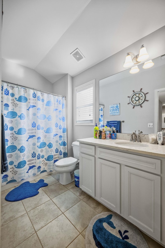 bathroom featuring vanity, tile patterned flooring, vaulted ceiling, and toilet