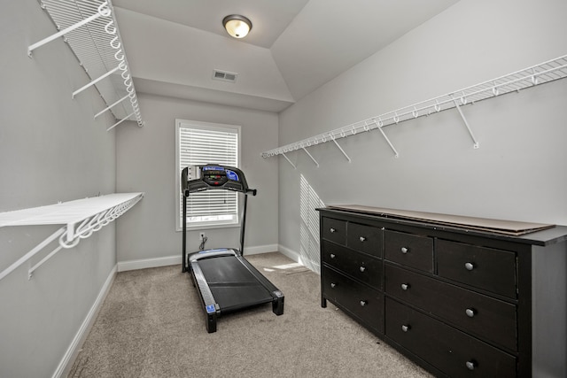 spacious closet featuring vaulted ceiling and light colored carpet