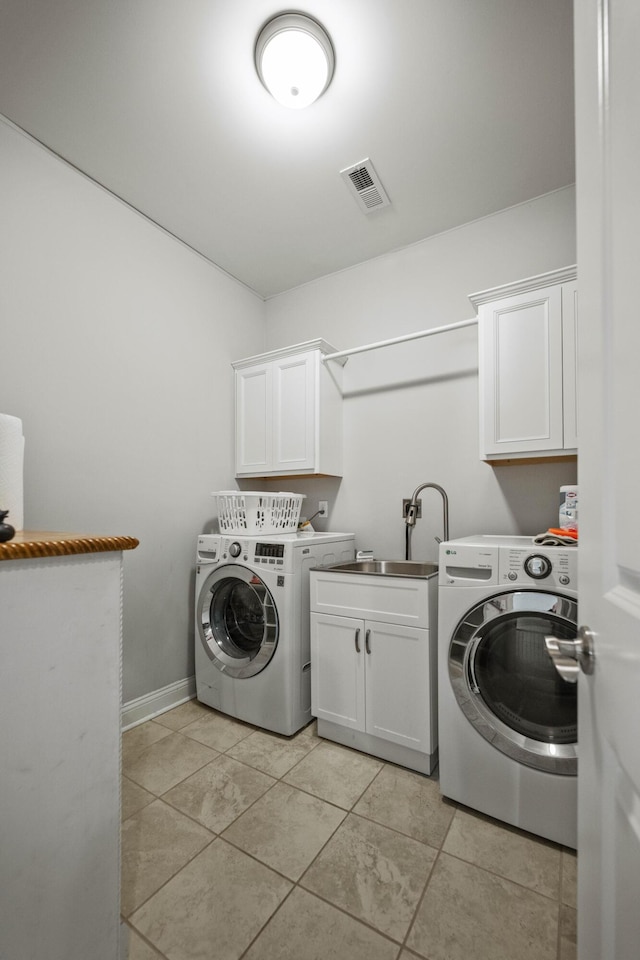 washroom featuring cabinets, separate washer and dryer, sink, and light tile patterned floors