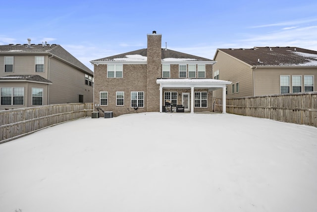 snow covered back of property with cooling unit