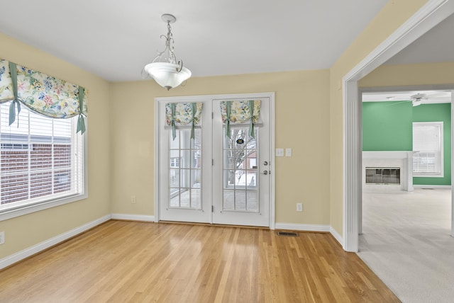 doorway featuring a fireplace and light hardwood / wood-style flooring