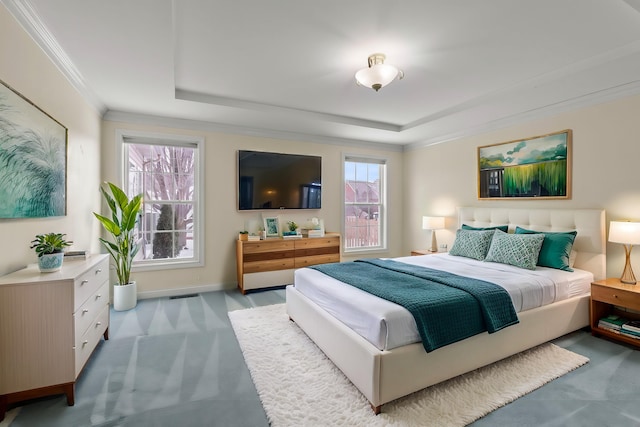 carpeted bedroom with a tray ceiling and ornamental molding