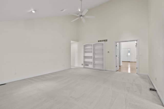 empty room featuring ceiling fan, light colored carpet, and high vaulted ceiling