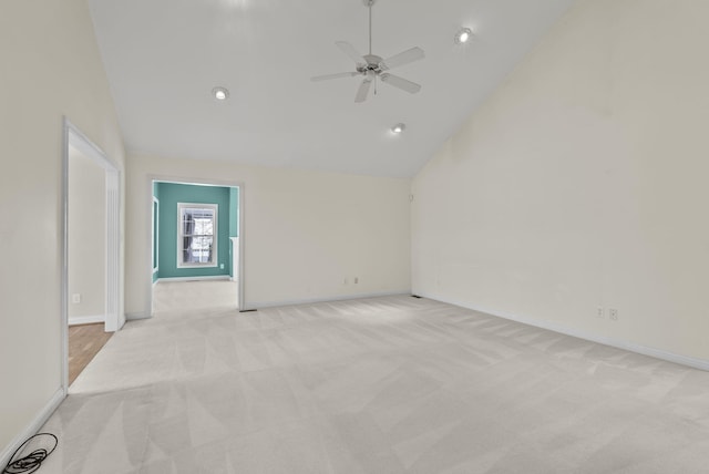 empty room featuring ceiling fan, light carpet, and high vaulted ceiling