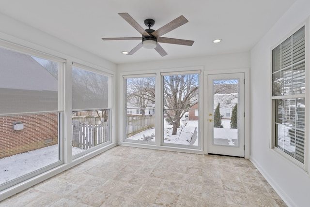 unfurnished sunroom with ceiling fan