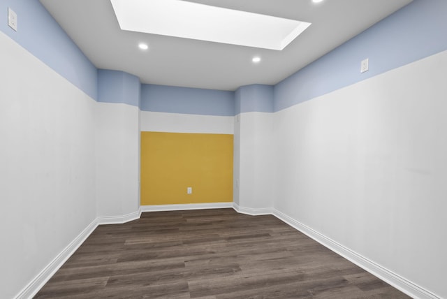 empty room with dark hardwood / wood-style floors and a skylight