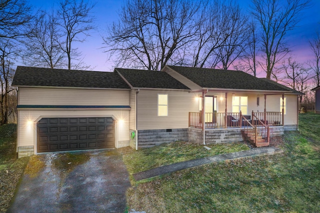 single story home featuring a garage, a lawn, and a porch