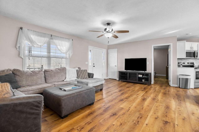 living room with ceiling fan and light hardwood / wood-style flooring