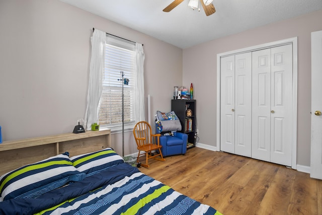 bedroom with ceiling fan, wood-type flooring, and a closet