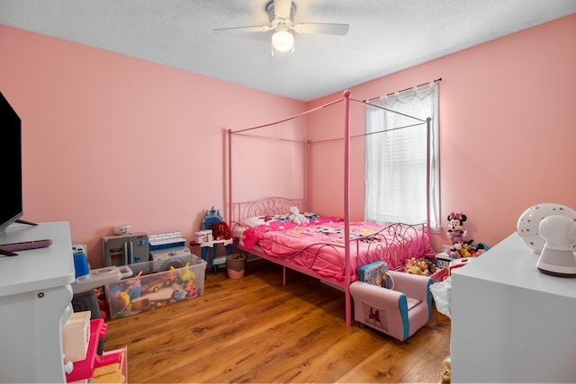 bedroom featuring a textured ceiling, wood-type flooring, and ceiling fan