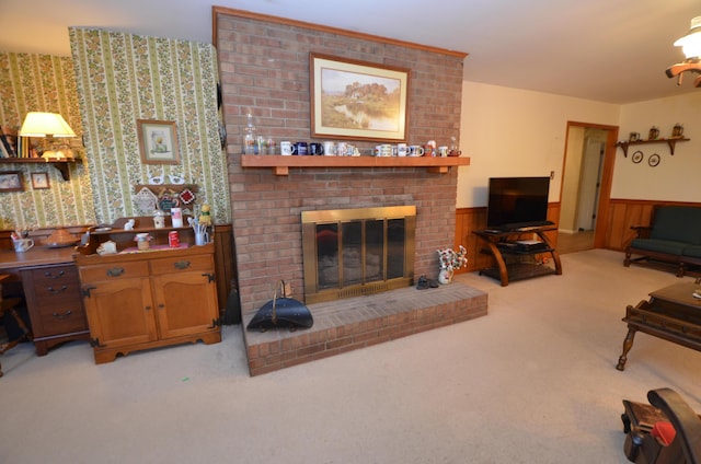 carpeted living room with a fireplace and wood walls