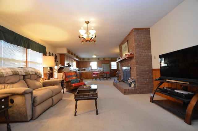 living room with an inviting chandelier, light carpet, and a fireplace