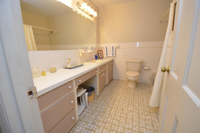 bathroom featuring tile patterned flooring, vanity, tile walls, and toilet