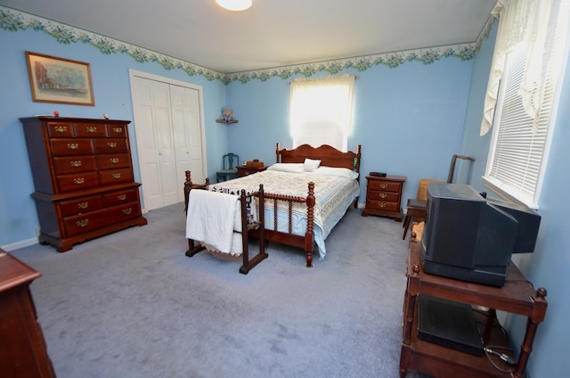 bedroom featuring light colored carpet and a closet