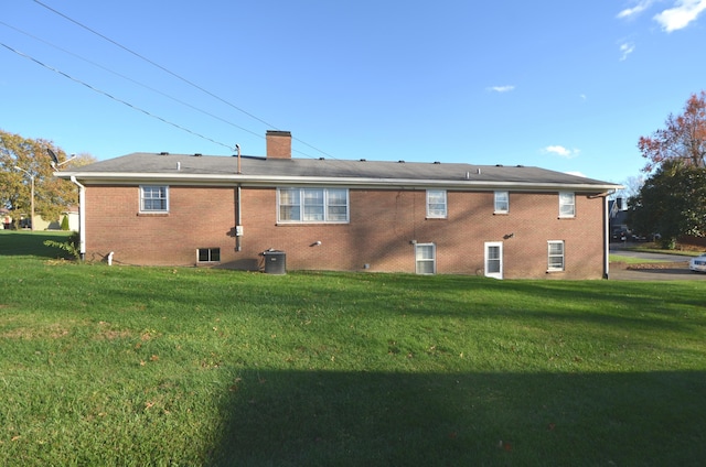 back of house with central AC and a lawn