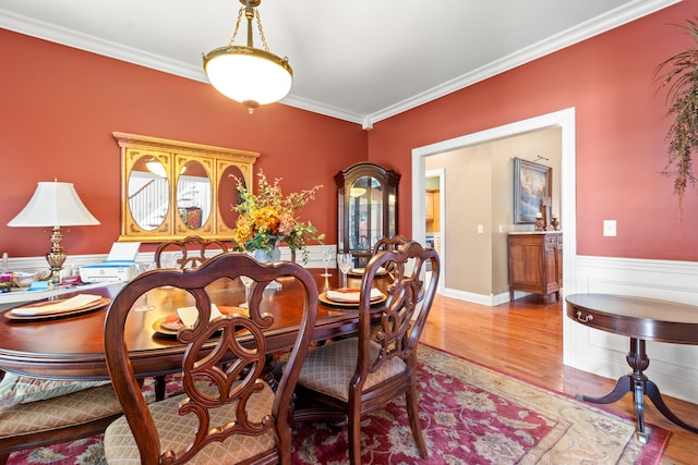 dining space featuring crown molding and light hardwood / wood-style floors