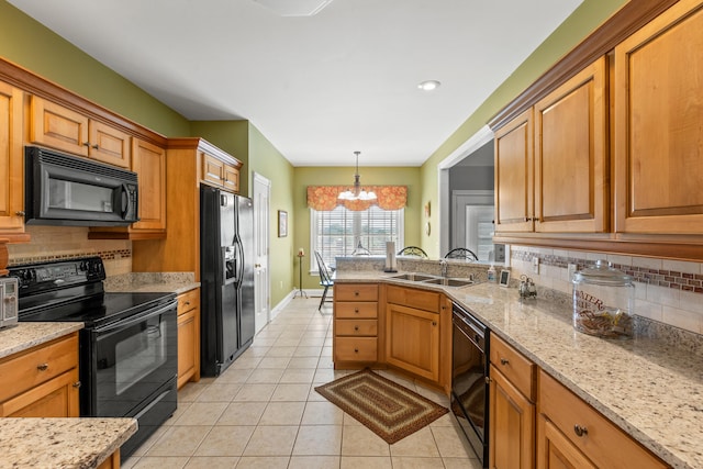 kitchen with decorative backsplash, hanging light fixtures, light tile patterned floors, black appliances, and an inviting chandelier