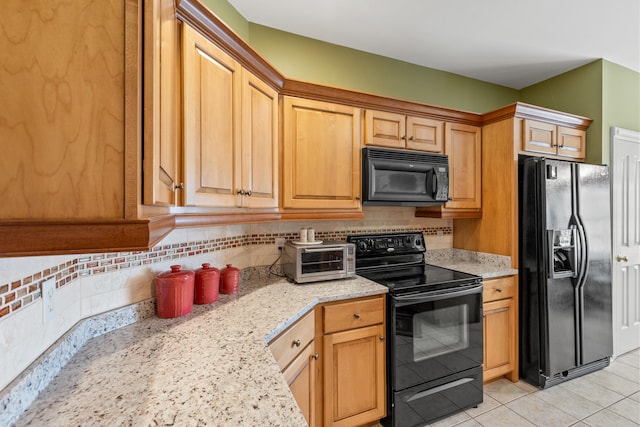 kitchen featuring light stone countertops, light tile patterned floors, decorative backsplash, and black appliances