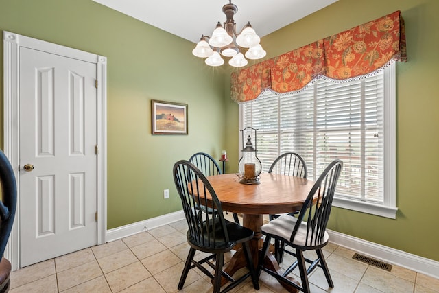 tiled dining space with a healthy amount of sunlight and a notable chandelier