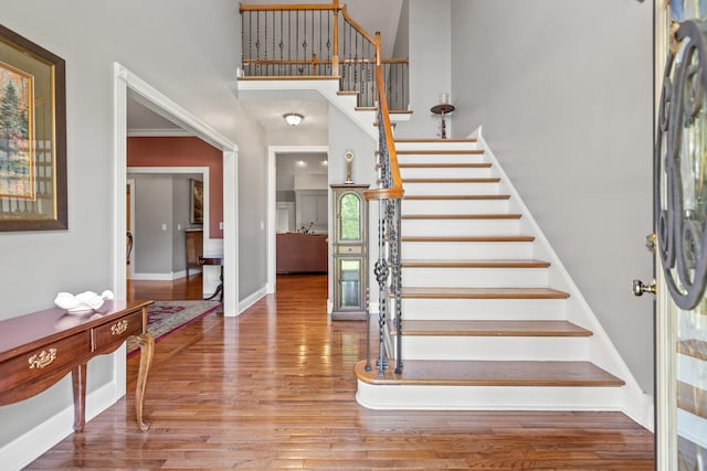 entryway with hardwood / wood-style floors and crown molding