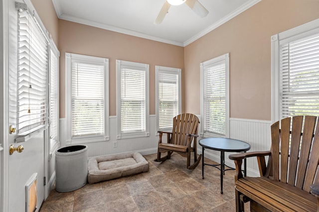 sitting room with ceiling fan, crown molding, and a healthy amount of sunlight