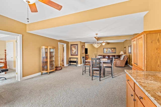 dining space featuring light colored carpet and ceiling fan