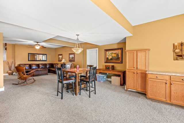 carpeted dining space with ceiling fan