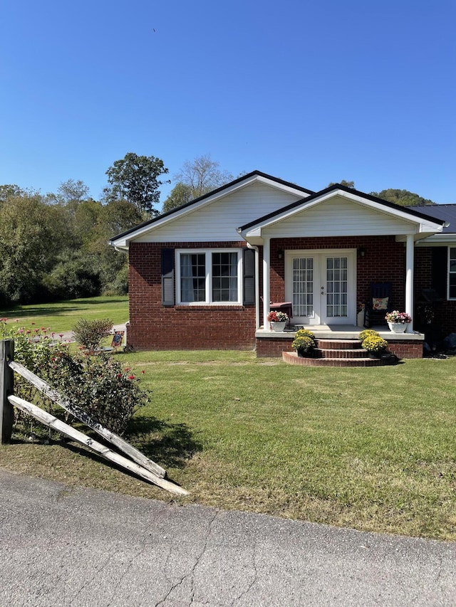 ranch-style house with french doors, a porch, and a front lawn