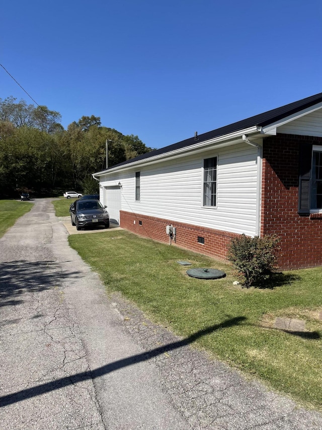 view of home's exterior featuring a garage and a lawn