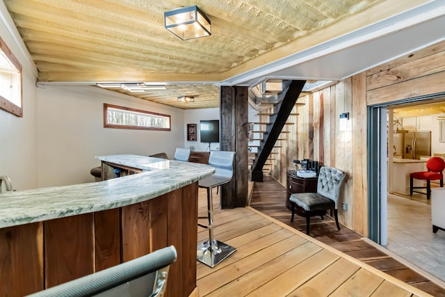 489 Sally J Rd, Mount Vernon, KY 40456 - indoor dry bar with light wood-style floors, stairway, stainless steel fridge, and wood walls