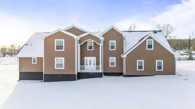 view of snow covered back of property