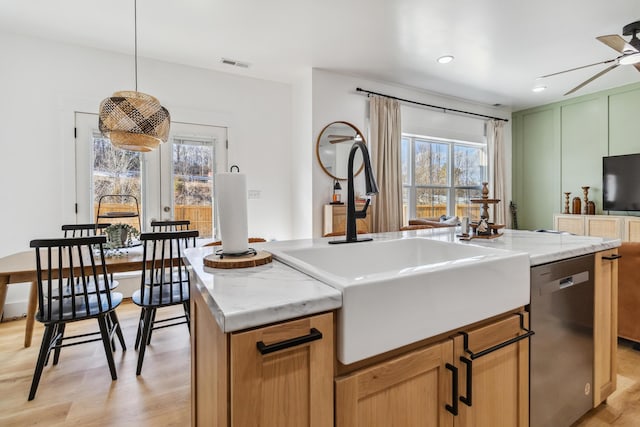 kitchen with sink, a center island, hanging light fixtures, light wood-type flooring, and dishwasher