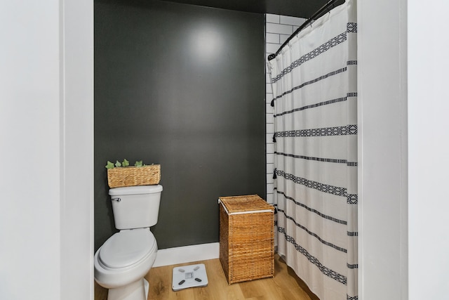 bathroom featuring a shower with curtain, hardwood / wood-style floors, and toilet