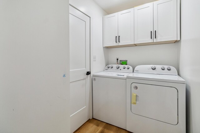 washroom featuring cabinets, washer and dryer, and light hardwood / wood-style floors