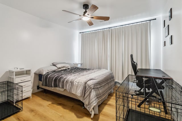 bedroom with light hardwood / wood-style floors and ceiling fan