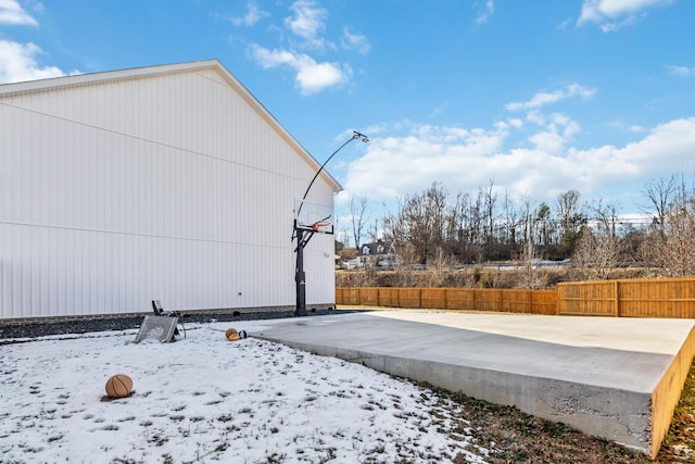 yard layered in snow featuring basketball hoop