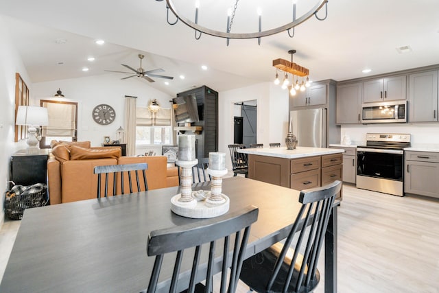 dining area featuring vaulted ceiling, ceiling fan, and light hardwood / wood-style floors