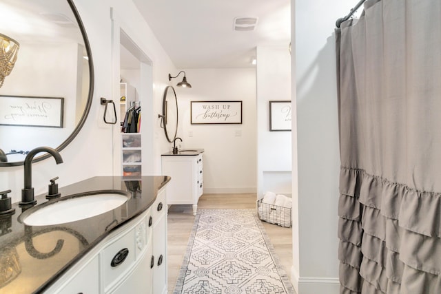 bathroom with vanity and wood-type flooring